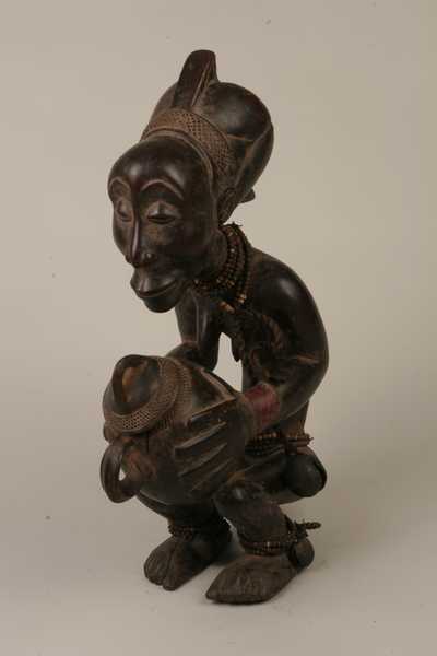 Luba (Buli), d`afrique : RÃ©p.dÃ©m. du Congo., statuette Luba (Buli), masque ancien africain Luba (Buli), art du RÃ©p.dÃ©m. du Congo. - Art Africain, collection privÃ©es Belgique. Statue africaine de la tribu des Luba (Buli), provenant du RÃ©p.dÃ©m. du Congo., 544/935.Porteuse de coupe appelÃ©e MBOKO, h56cm.bois pigmentÃ© foncÃ©,perles et grelot. Femme accroupie tenant une coupe dans la main,en parfait Ã©quilibre.Le rendu expressionniste du visage et des mains tenant la coupe avec couvercle est typiquement de l