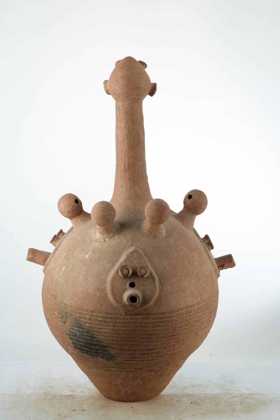 Dogon.(vase), d`afrique : Mali, statuette Dogon.(vase), masque ancien africain Dogon.(vase), art du Mali - Art Africain, collection privées Belgique. Statue africaine de la tribu des Dogon.(vase), provenant du Mali, 1973 Vase BANKONI de cérémonie funéraire en terre cuite .Le vase est ouvert par la base.Il a une H.de 118cm.et un diam.de60cm.Il représente un corps avec un long cou plus la tête 45cm.  Sur le corps 4 petites boules représentant des têtes avec 3 trous  sybolisant  le nez et  deux yeux en plus  deux petits bras.Sous les petites têtes 3 visages plats avec 2 yeux ,un nez et une bouche allongée trouée. pour laisser passer la fumée.Les traits anthropomorphes accompagnaient les hommes dans les rites rythmant leur existance,le lien sacré entre le vivant et l